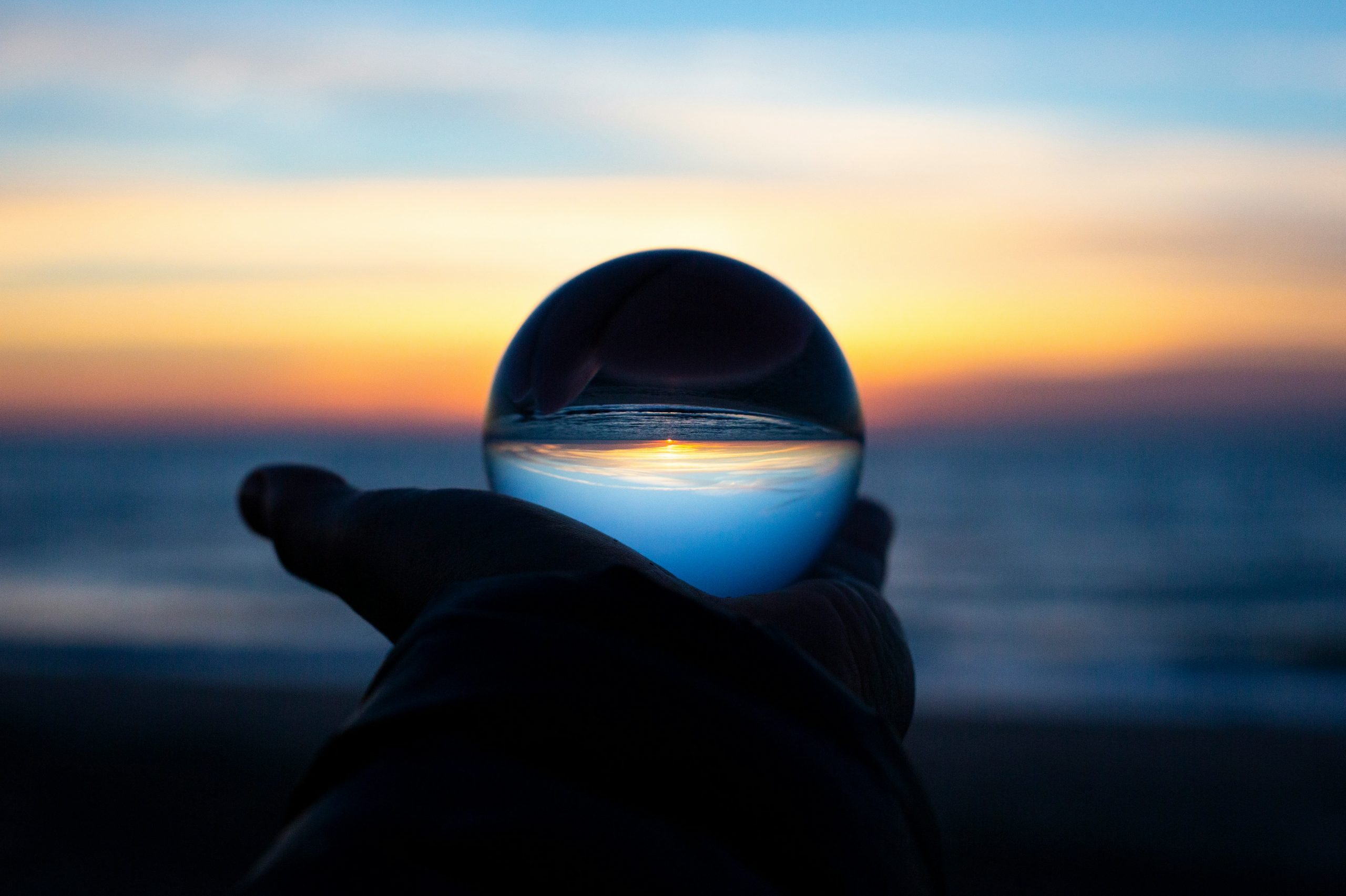 Image of glass sphere reflecting the sunset behind it